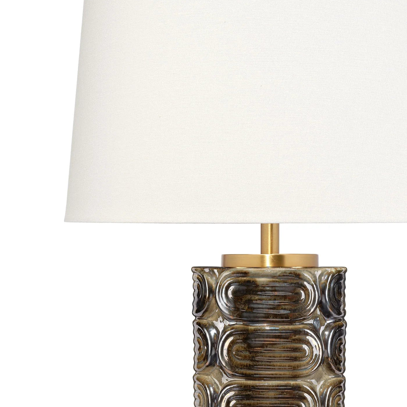 Decorative table lamp with a textured base and white shade on a white background
