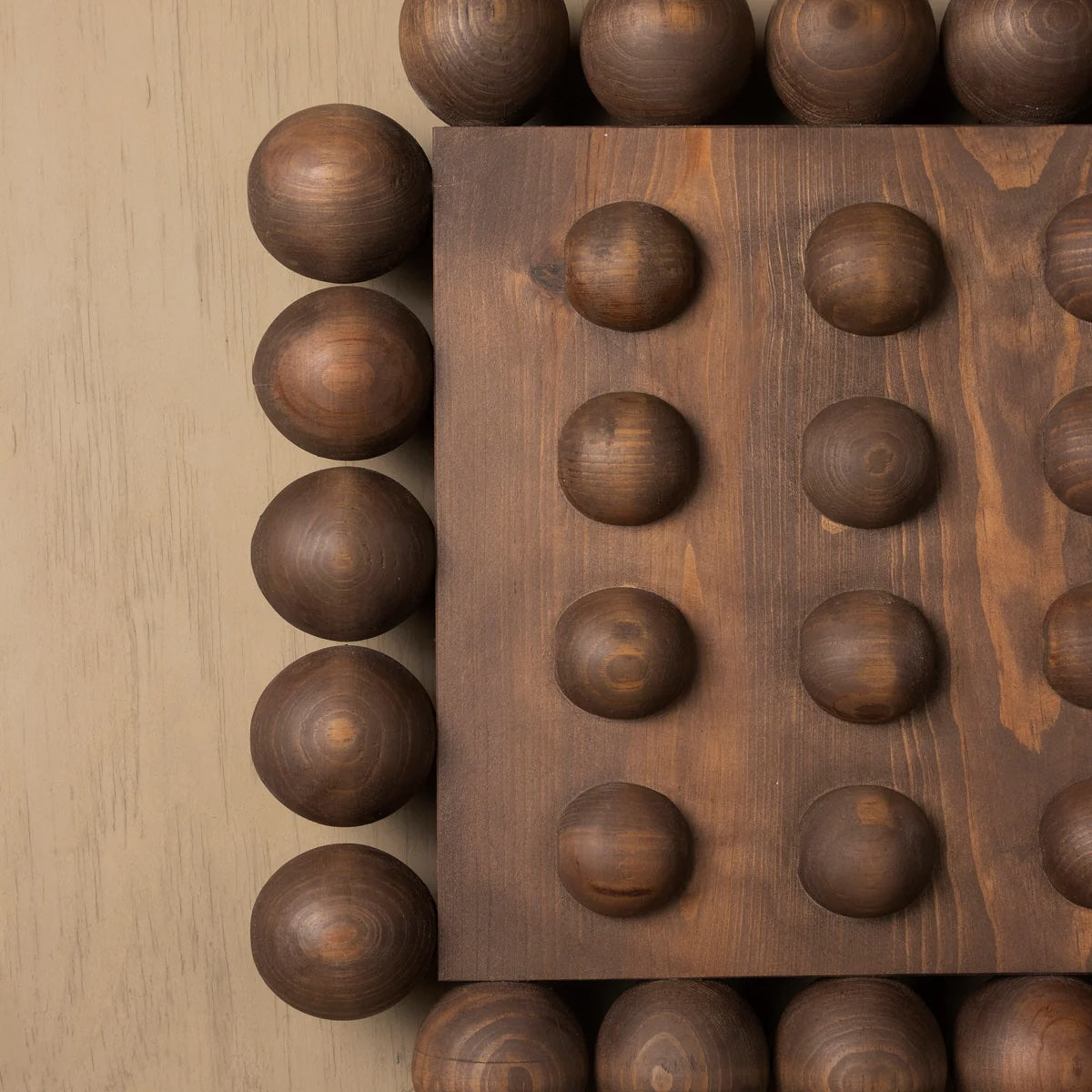 Wooden block with spherical protrusions on a wooden surface
