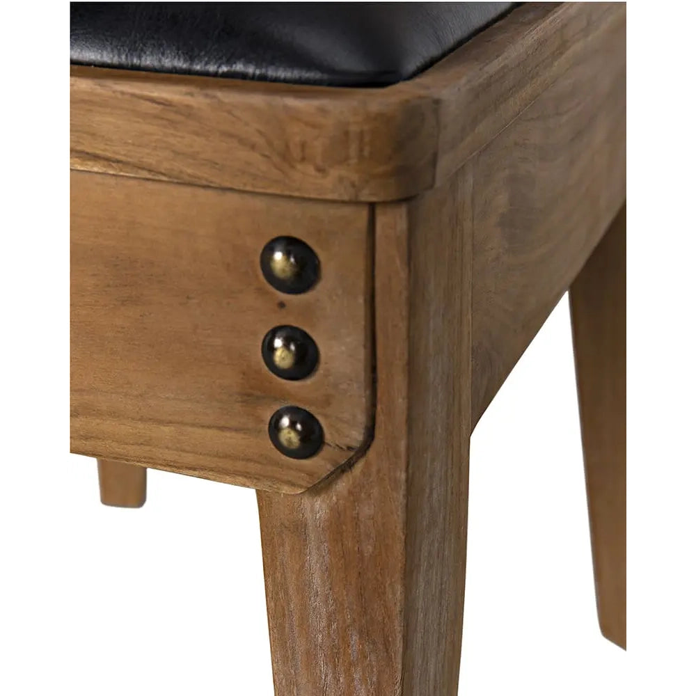 Wooden chair with black cushioned seat and brass knobs on a white background