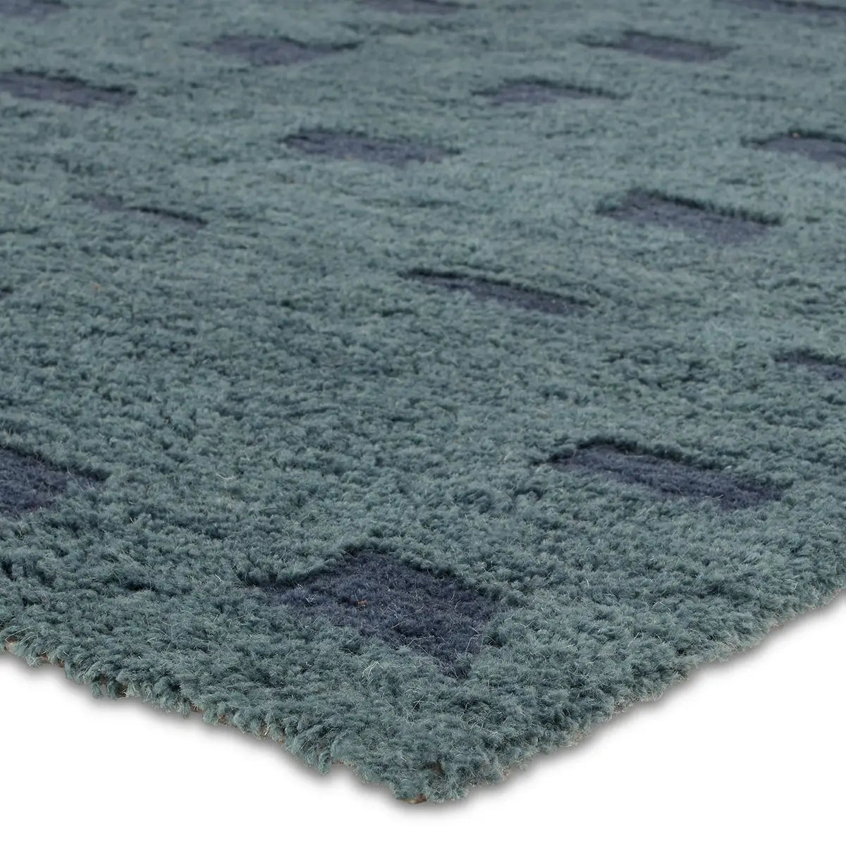 Close-up of a textured blue rug with geometric pattern