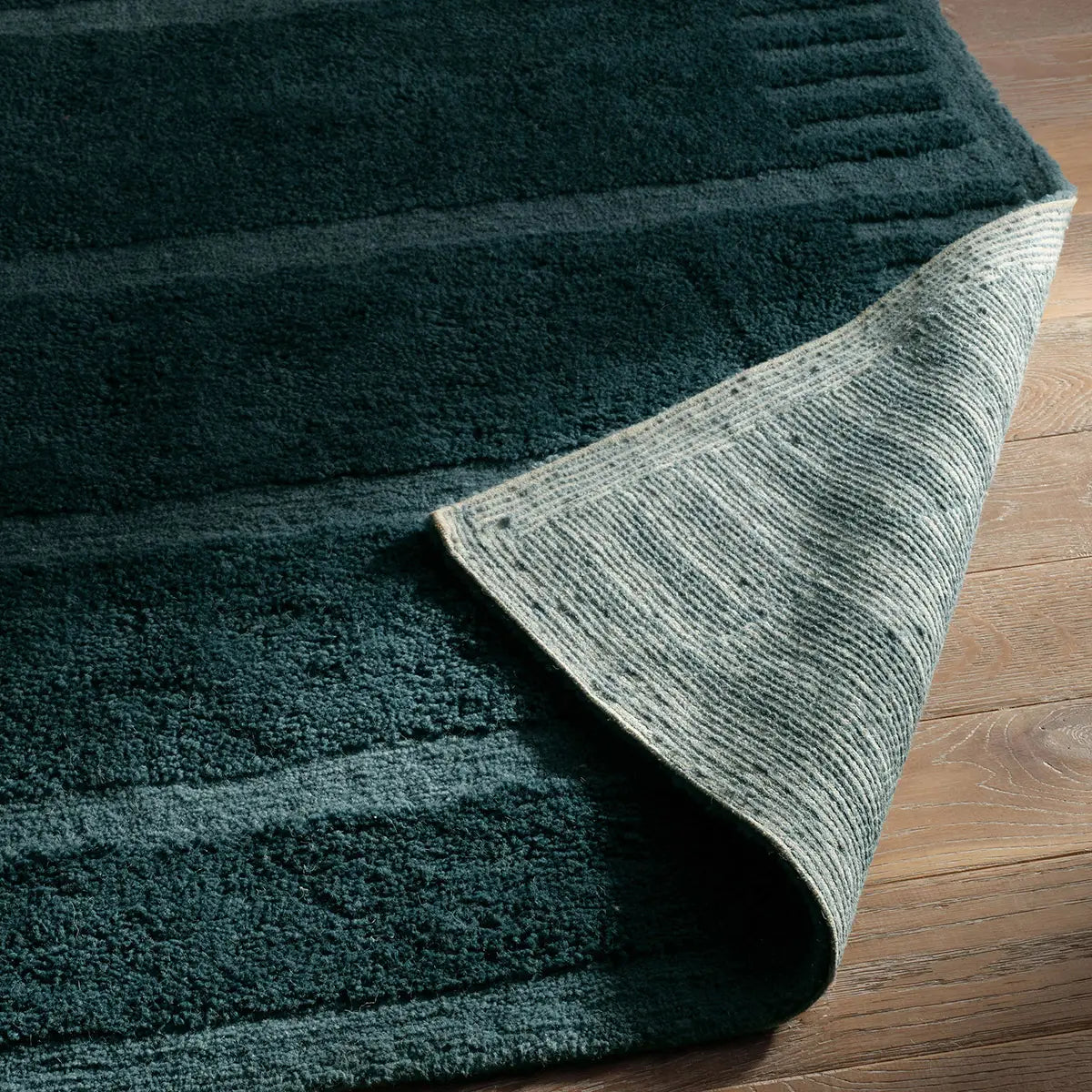 Green textured rug on a wooden floor