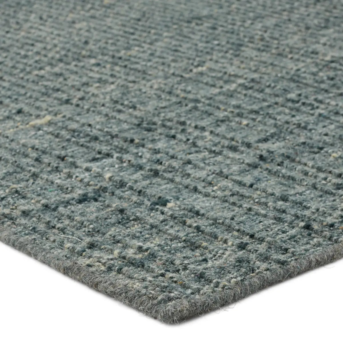 Close-up of a textured blue rug corner on a white background