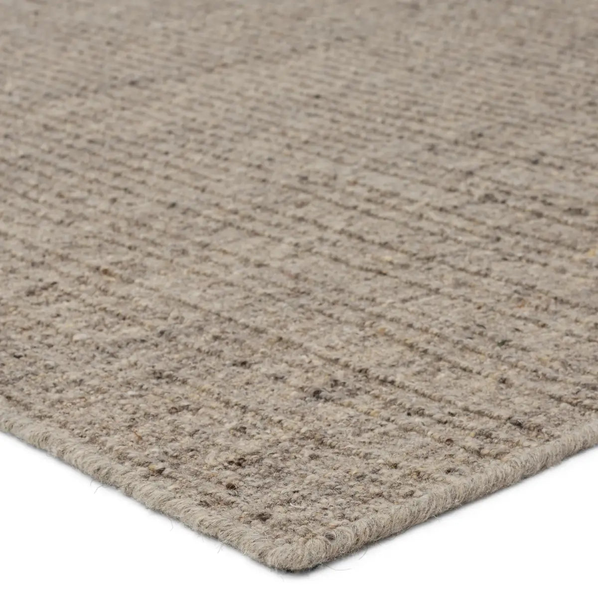 Close-up of a textured beige rug corner on a white background