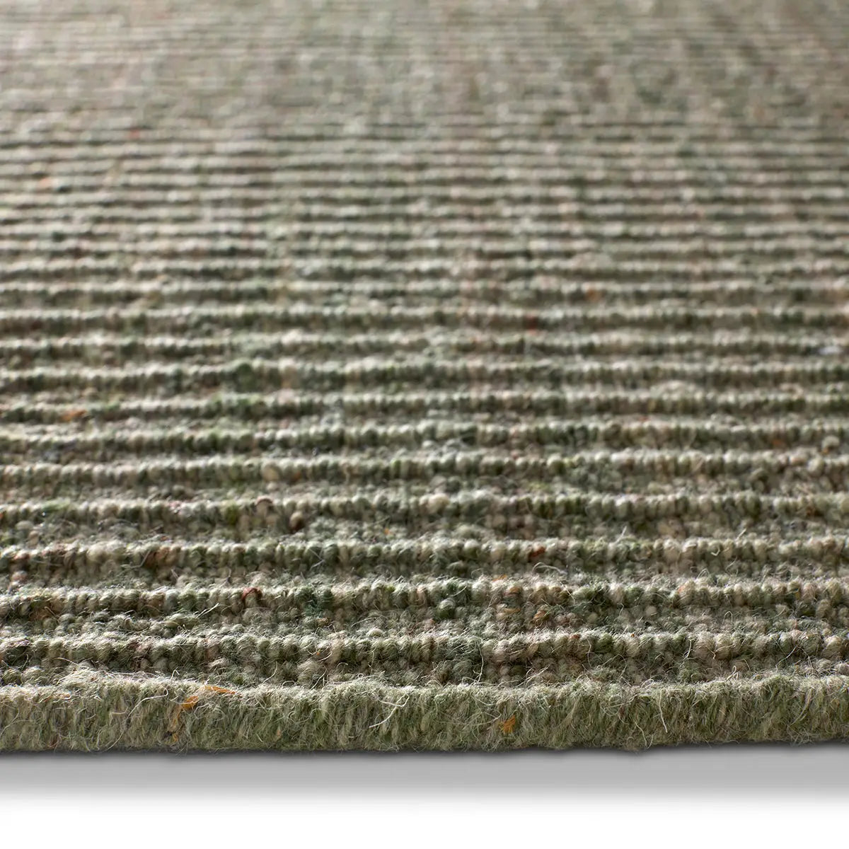 Close-up of a textured green rug with a white background
