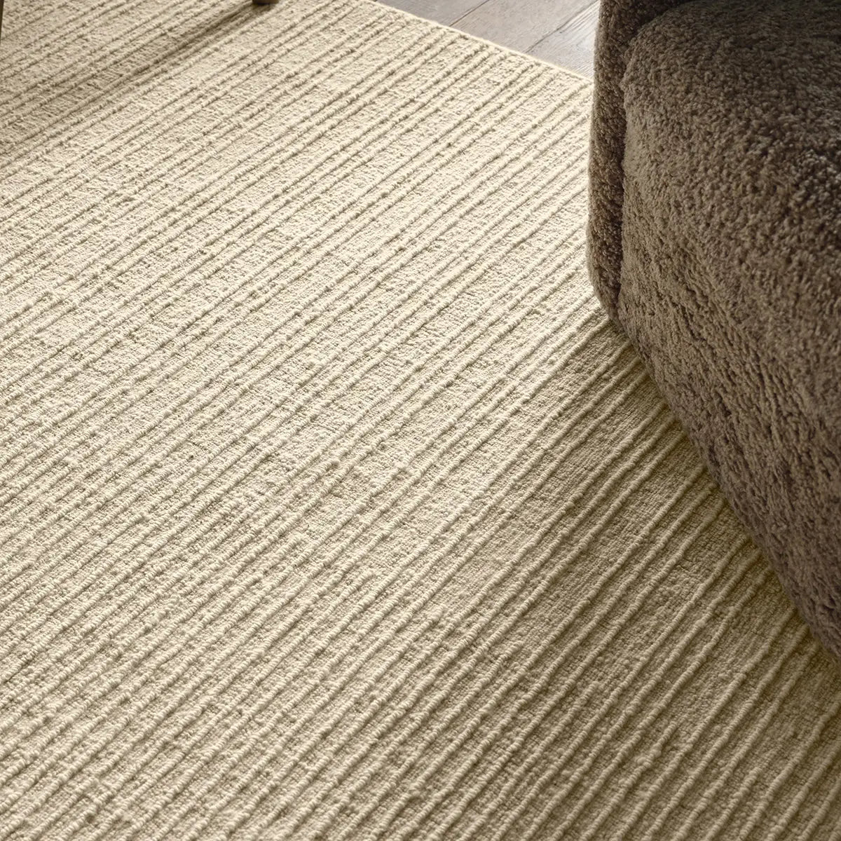 Living room with a beige rug and a brown armchair.