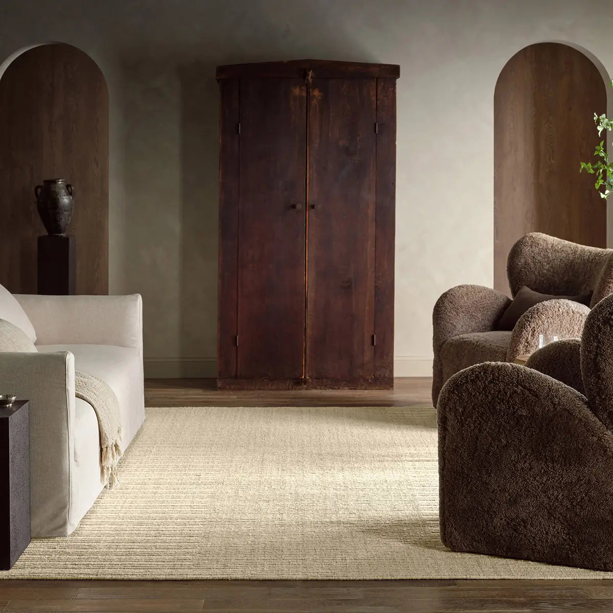 Living room with a wooden wardrobe, beige rug, and brown armchair.
