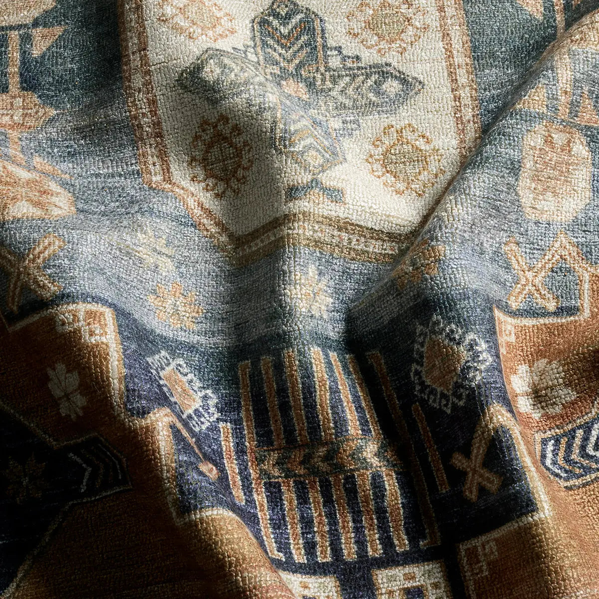 Close-up of a patterned fabric with geometric designs in blue, brown, and beige.