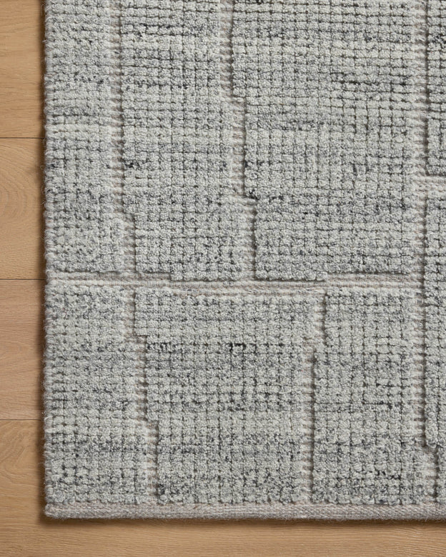 Close-up of a textured gray rug on a wooden floor