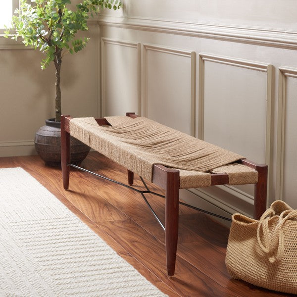 Woven bench with wooden legs in a room with wainscoting and a plant.