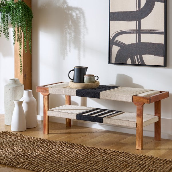 Wooden bench with woven seat in a room with abstract art and vases.