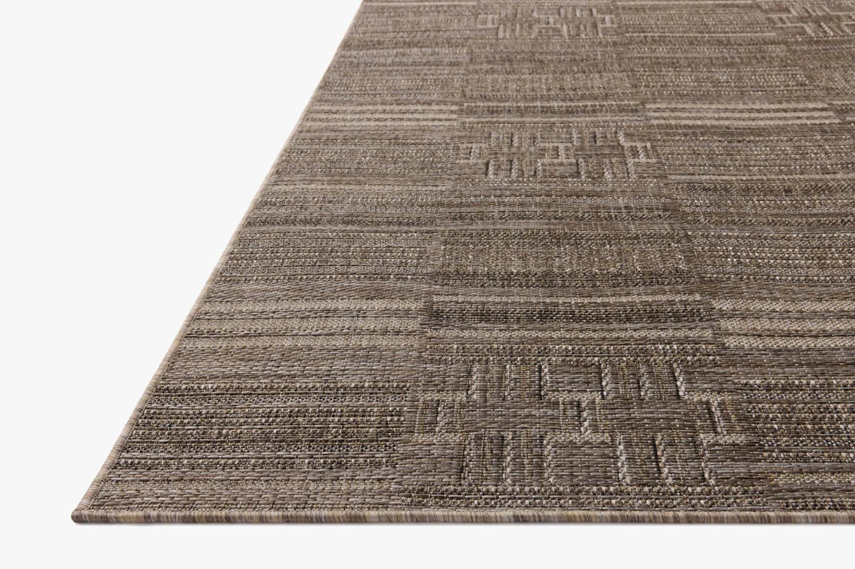 Close-up of a textured brown rug with geometric pattern on a white background
