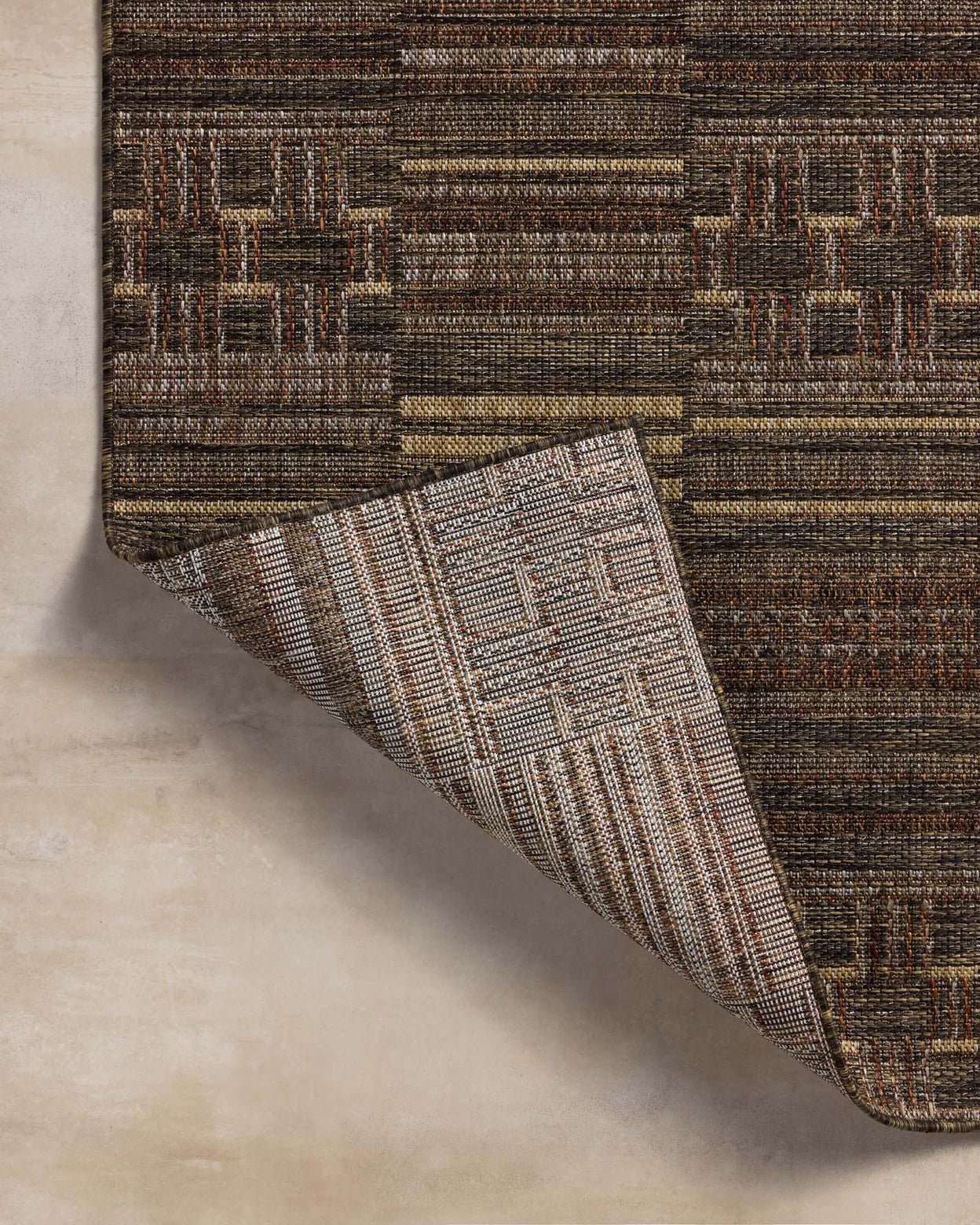 Textured brown and beige area rug on a light wood floor