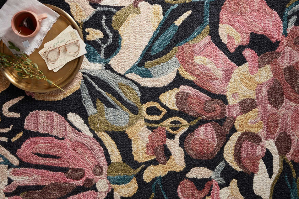 Floral patterned rug with a pink flower design on a dark background
