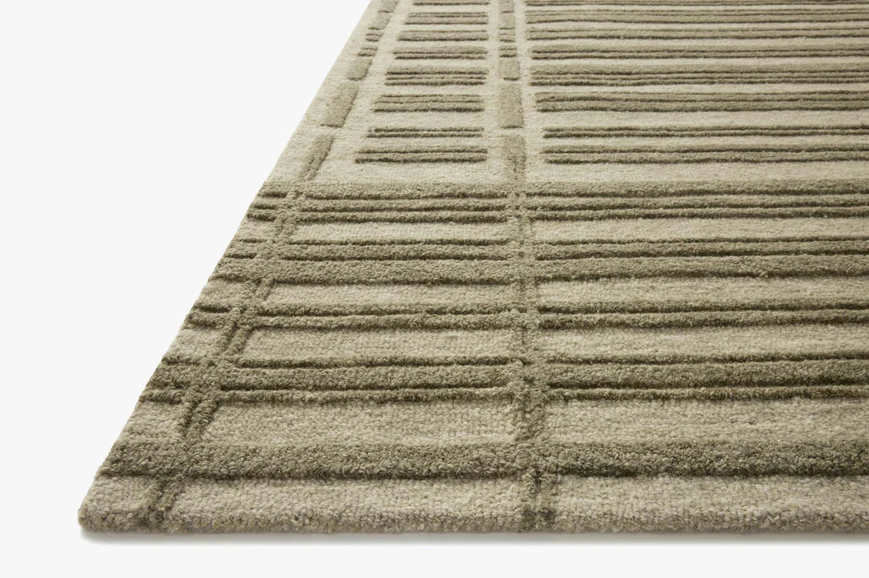 A rectangular, striped rug with varying shades of gray and beige, representing a geometric pattern.