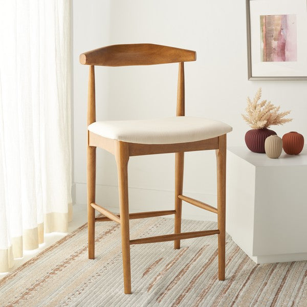 Wooden bar stool with a white cushion in a room with a window and decorative items.