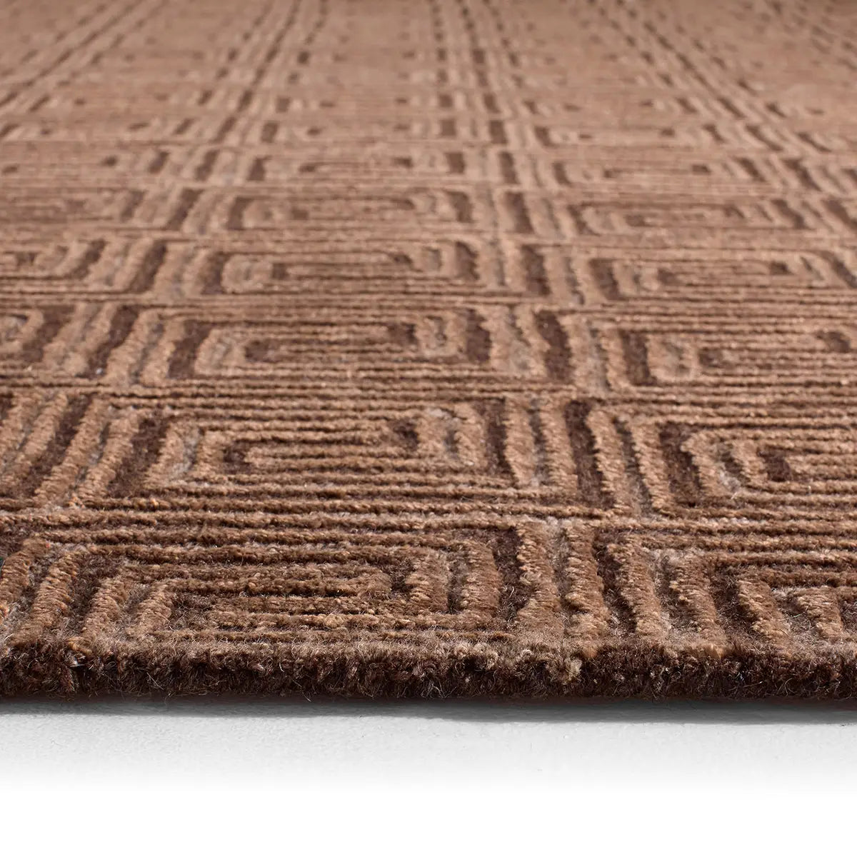 Close-up of a brown textured rug with geometric pattern on a white background
