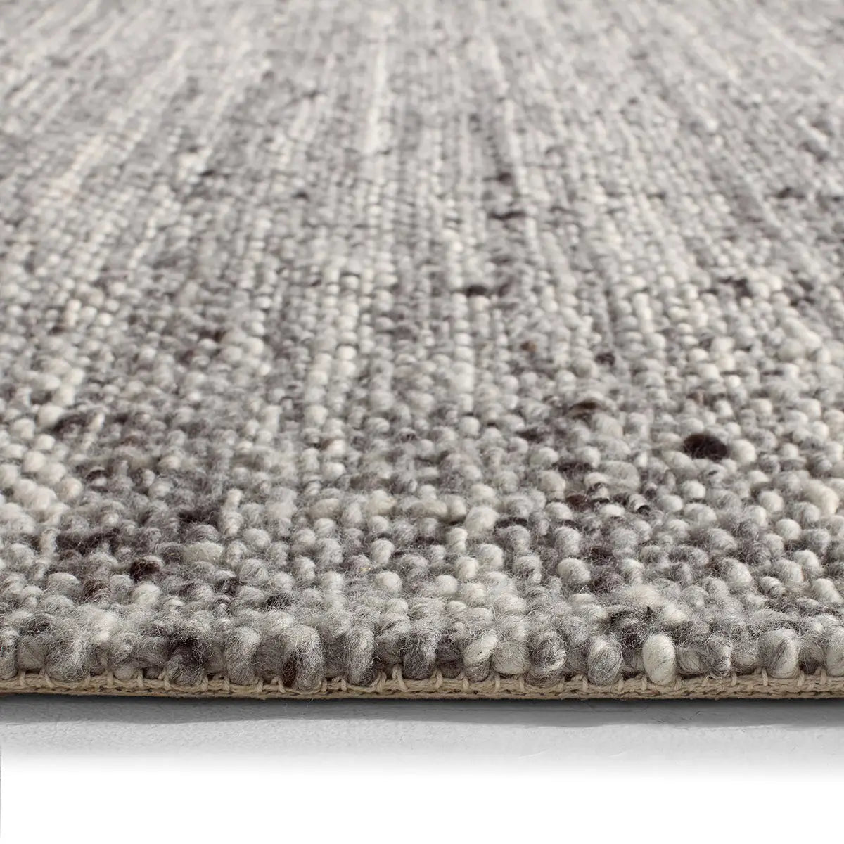 Close-up of a textured gray rug on a white background