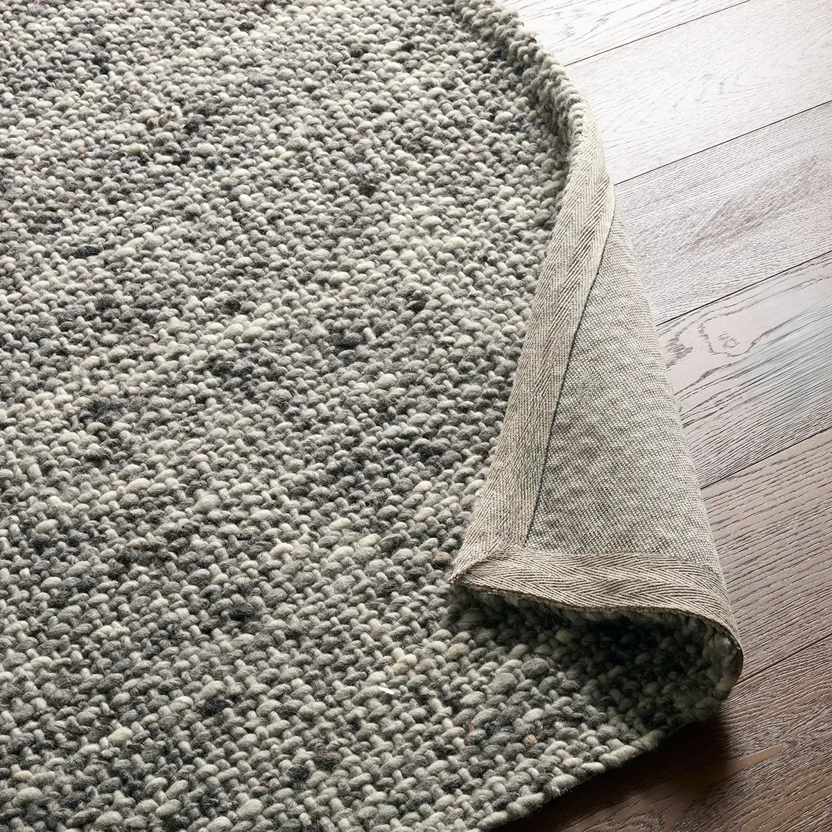 Gray textured rug on a wooden floor
