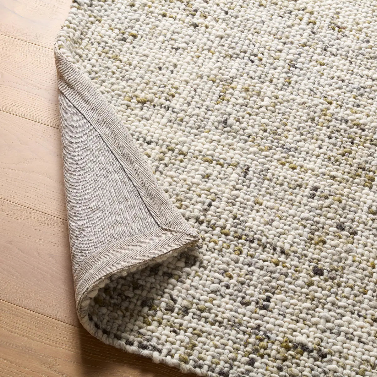 Textured beige rug on a wooden floor