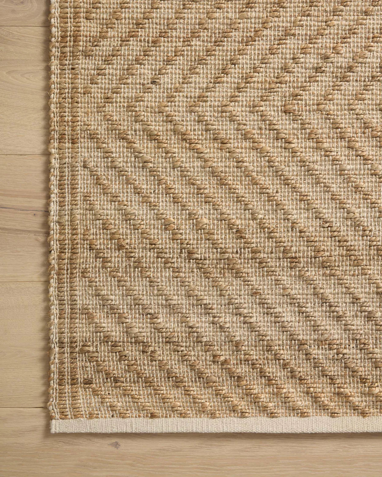 Close-up of a woven jute rug on a wooden floor