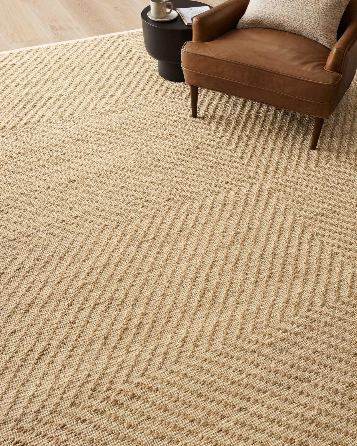 Beige textured rug with a brown chair in the corner