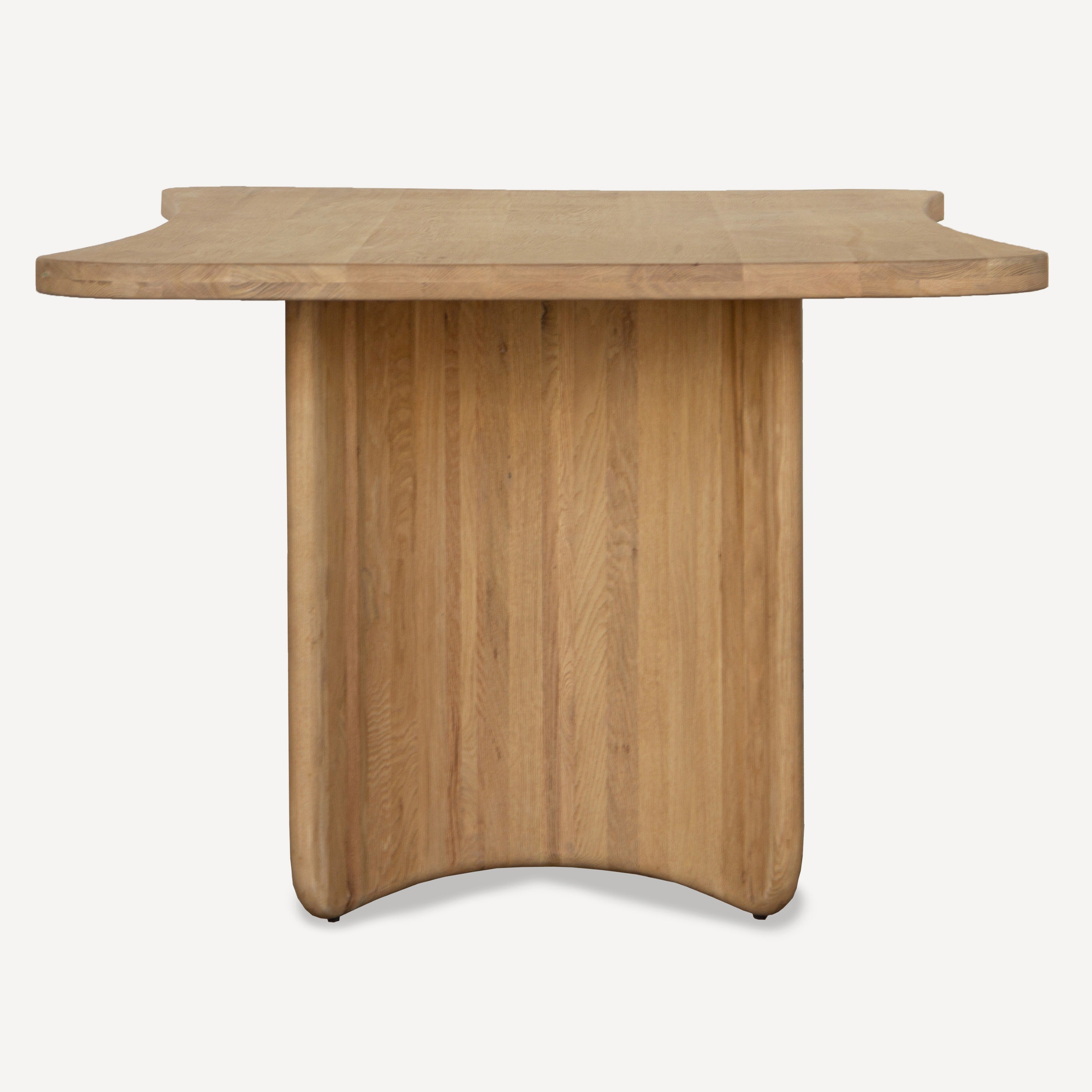 A modern wooden dining table with a curved, scalloped top and a matching curved pedestal base, shown against a plain light gray background.