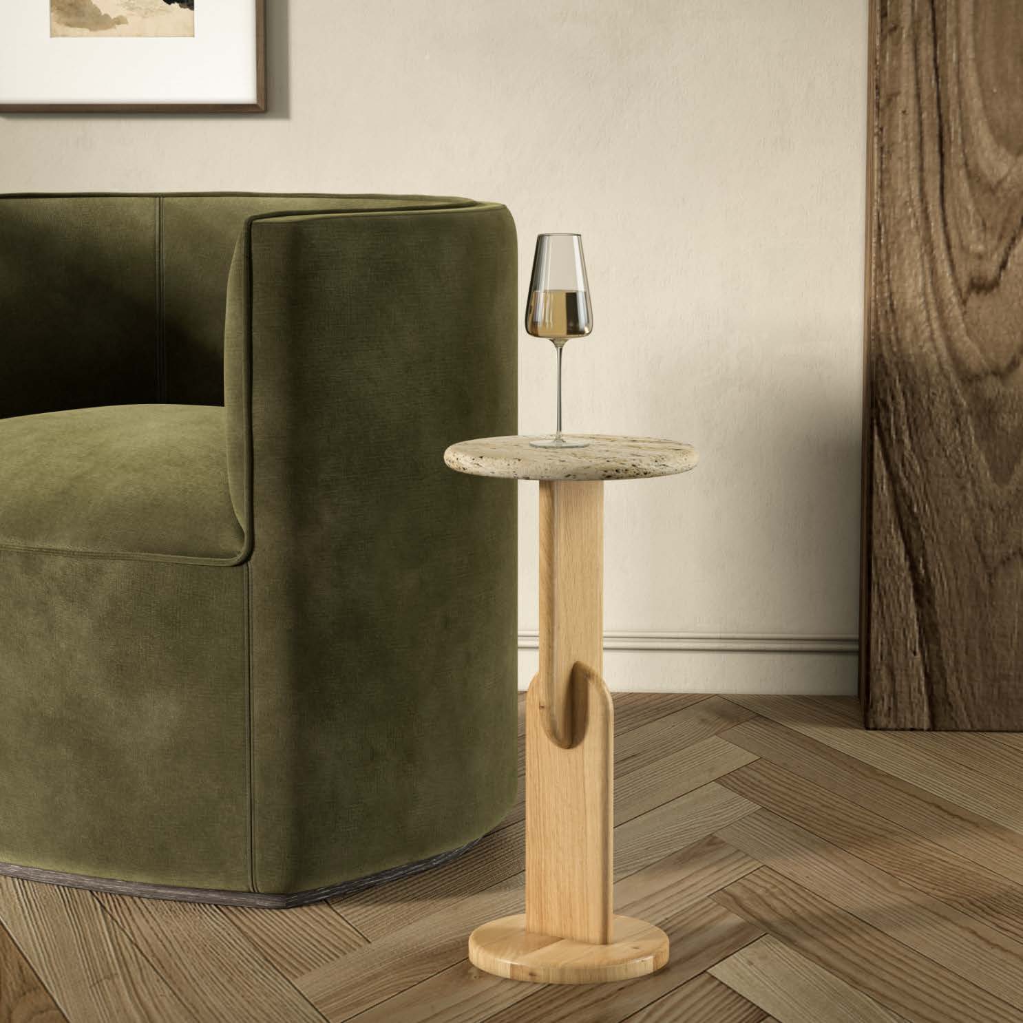 Green sofa with a wooden side table and a glass of wine in a room with a wooden floor and framed picture on the wall.