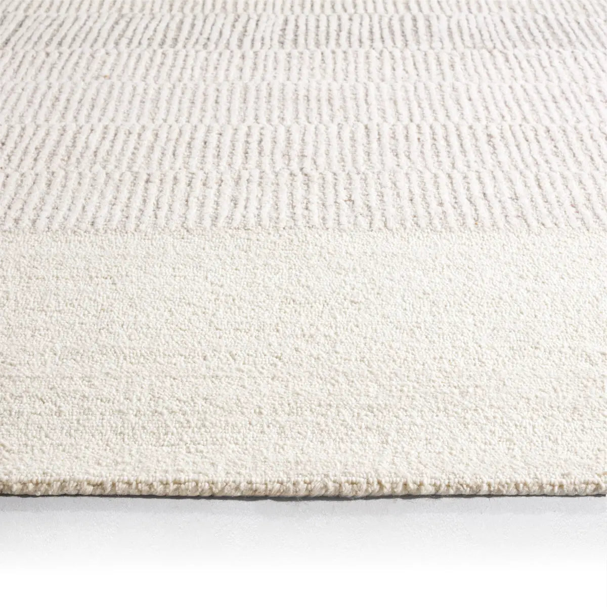 Close-up of a textured white rug on a light gray background