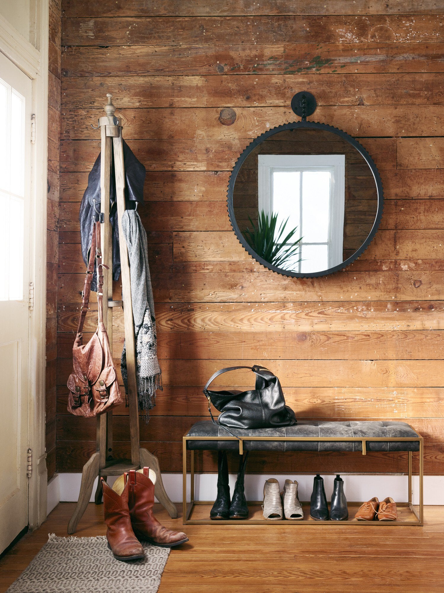Entryway with wooden wall, coat rack, mirror, and bench.