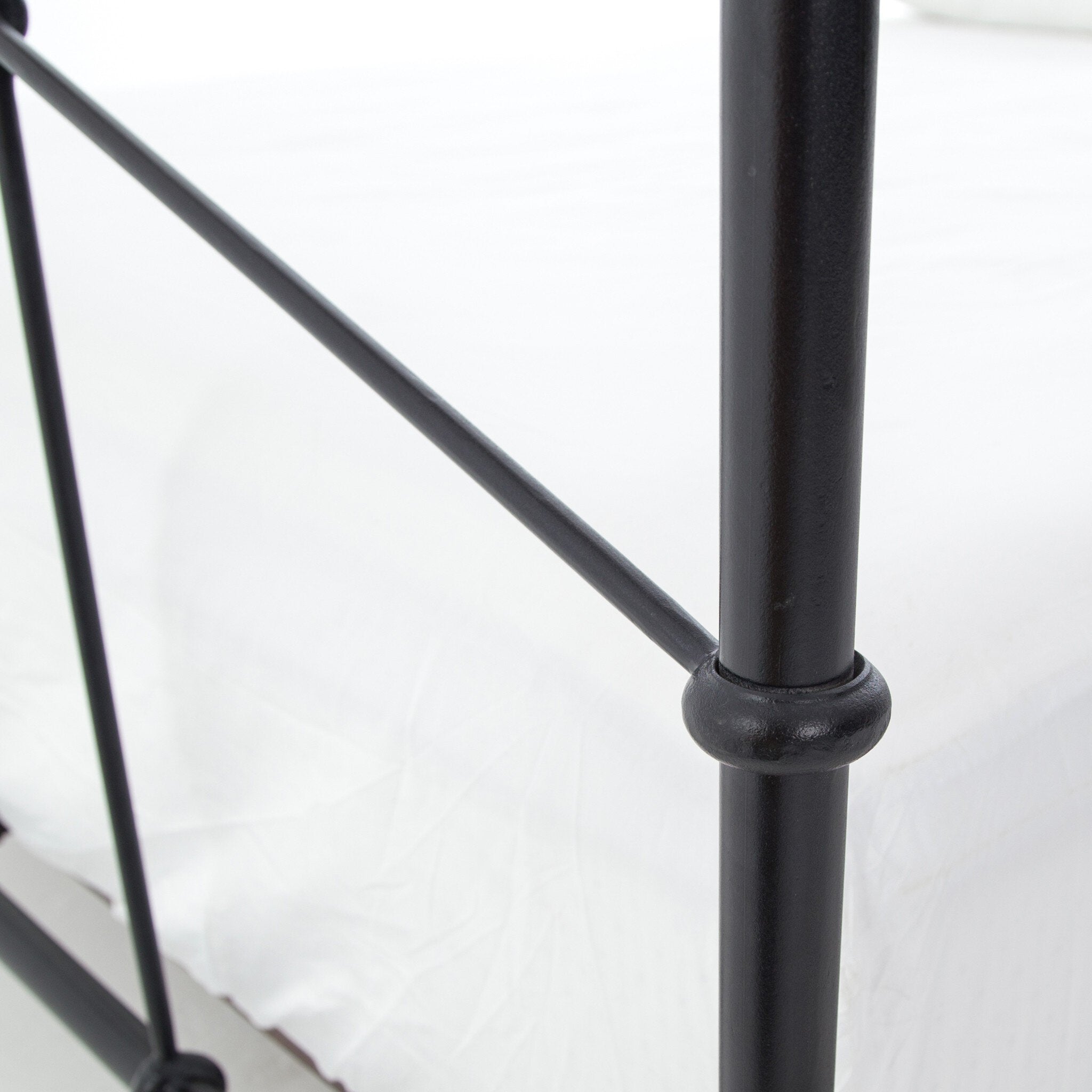Close-up of a black metal bed frame on a white background