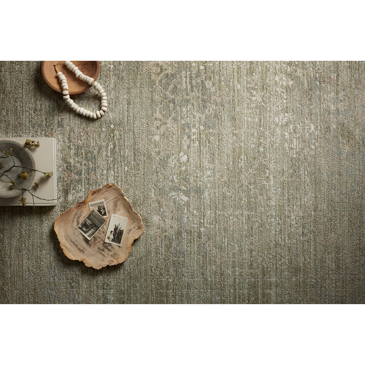 Textured green rug with decorative items on a white background