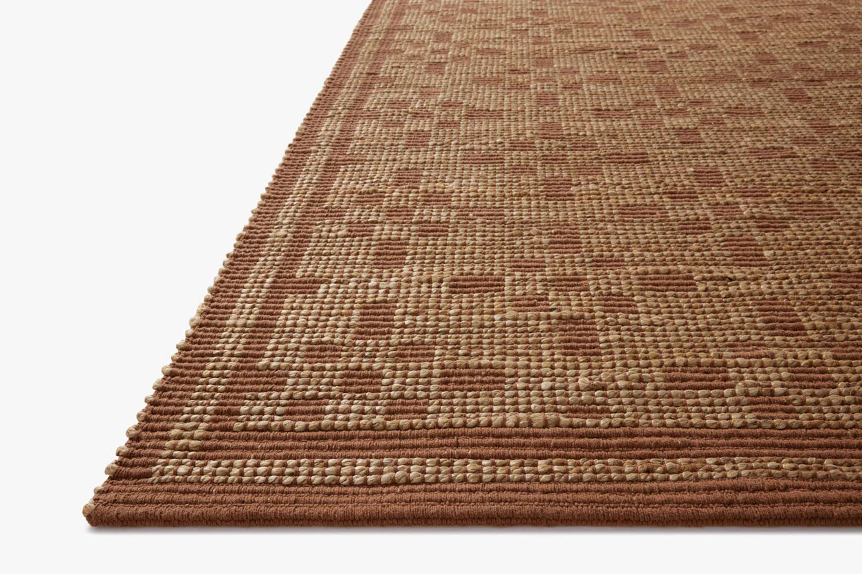 Close-up of a brown textured rug on a plain background.