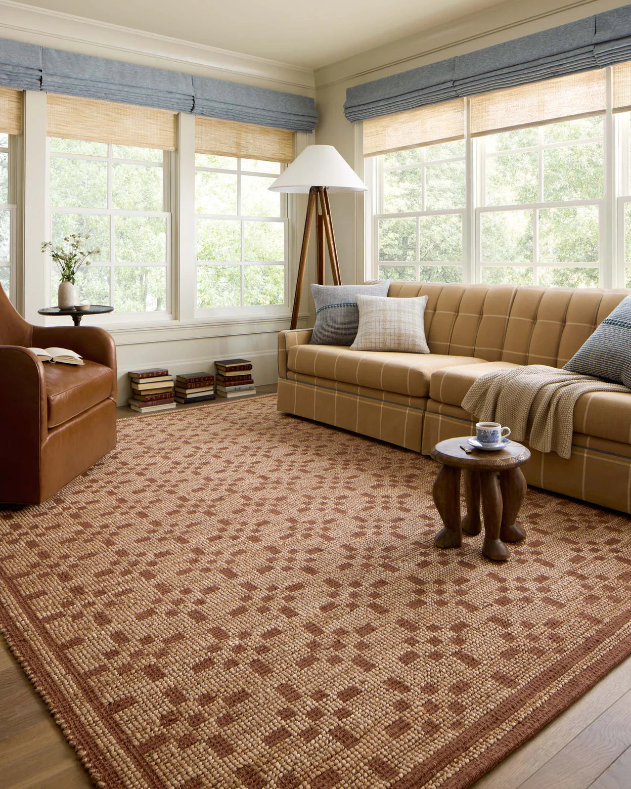 Living room with beige sofa, patterned rug, and window treatments.