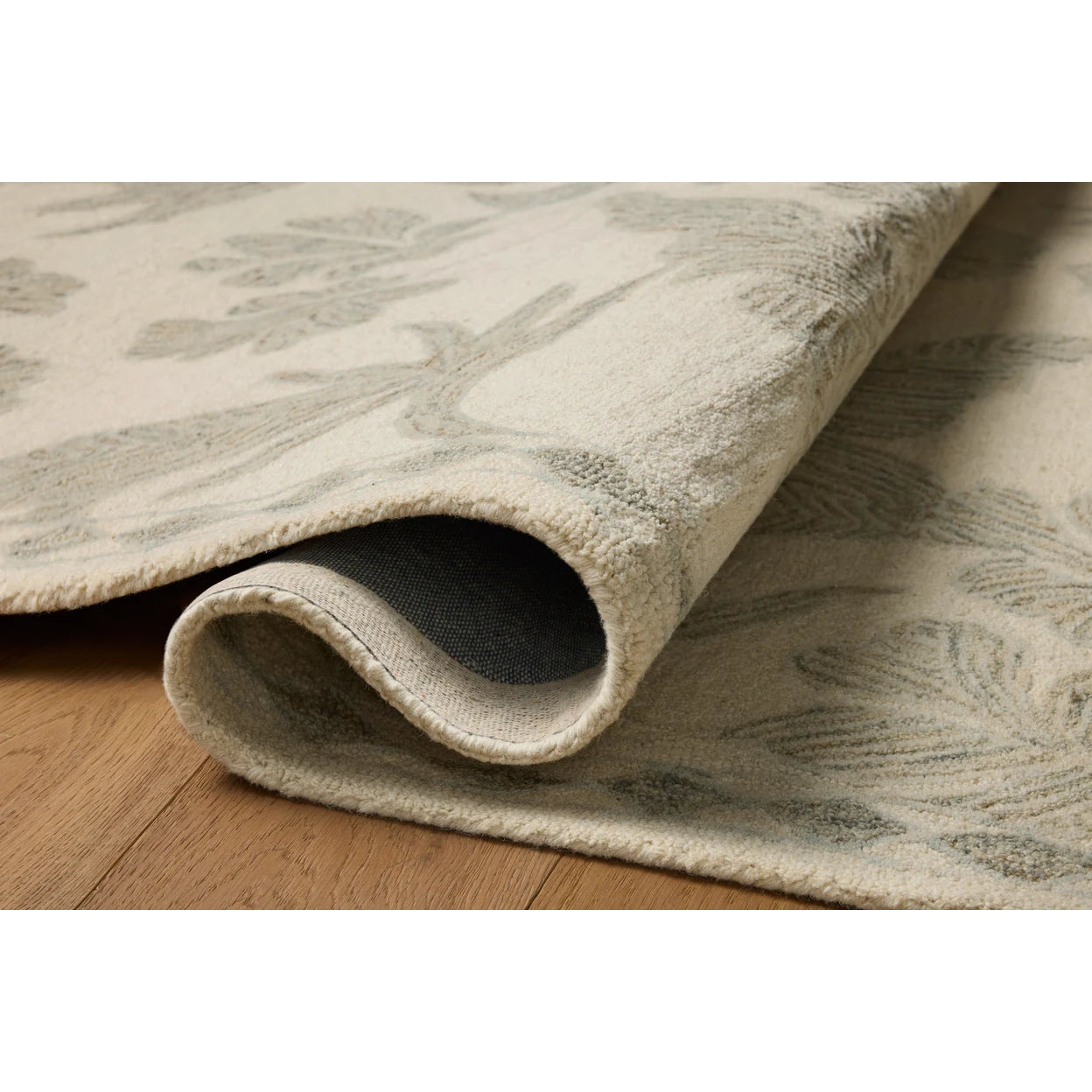 Close-up of a beige patterned rug on a wooden floor
