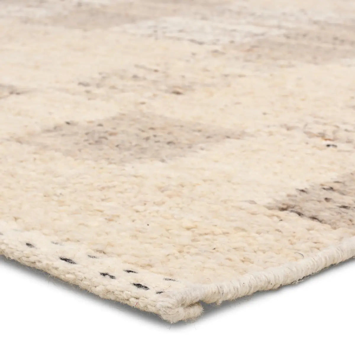 Close-up of a textured beige rug corner on a white background