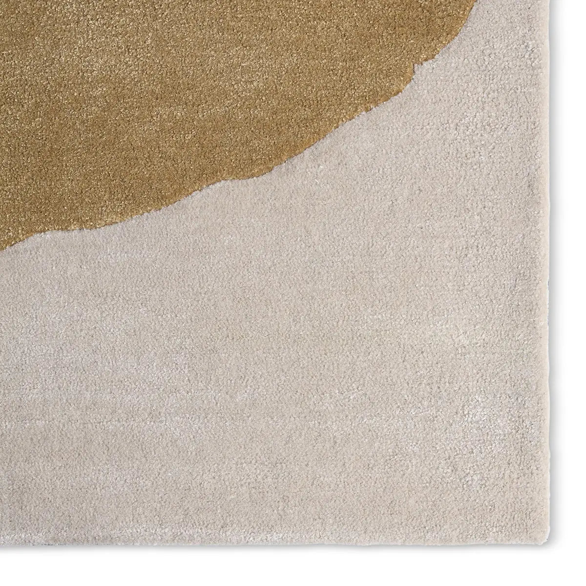 Close-up of a textured rug with a gold and beige color scheme.