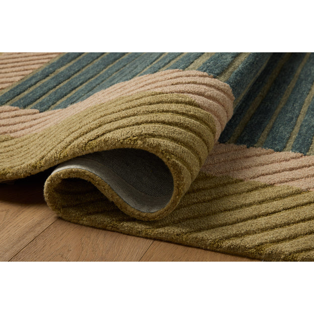 Textured green, blue, and beige rug on a wooden floor