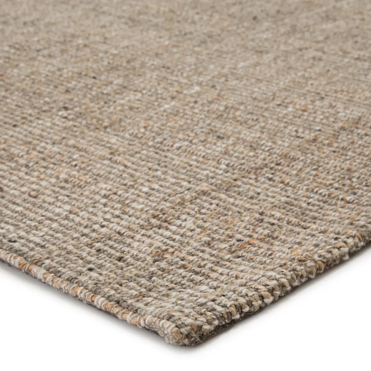 Close-up of a textured beige rug corner on a white background