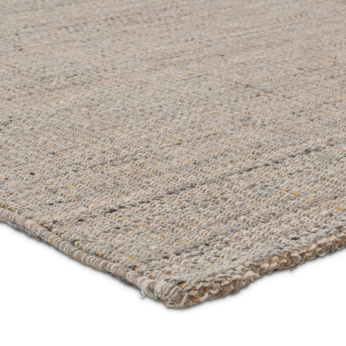 Close-up of a textured beige rug corner on a white background