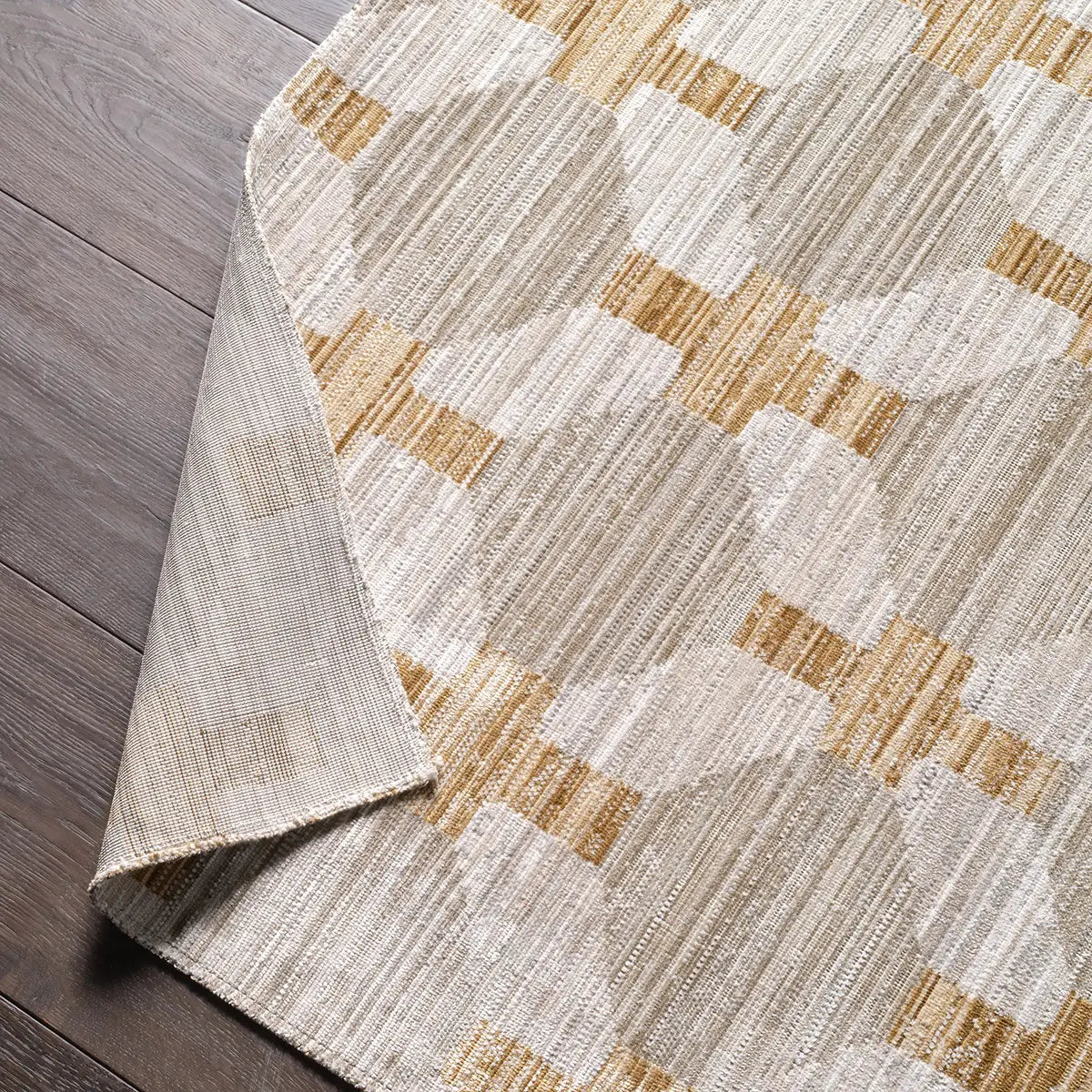 Close-up of a textured area rug with geometric pattern on wooden floor