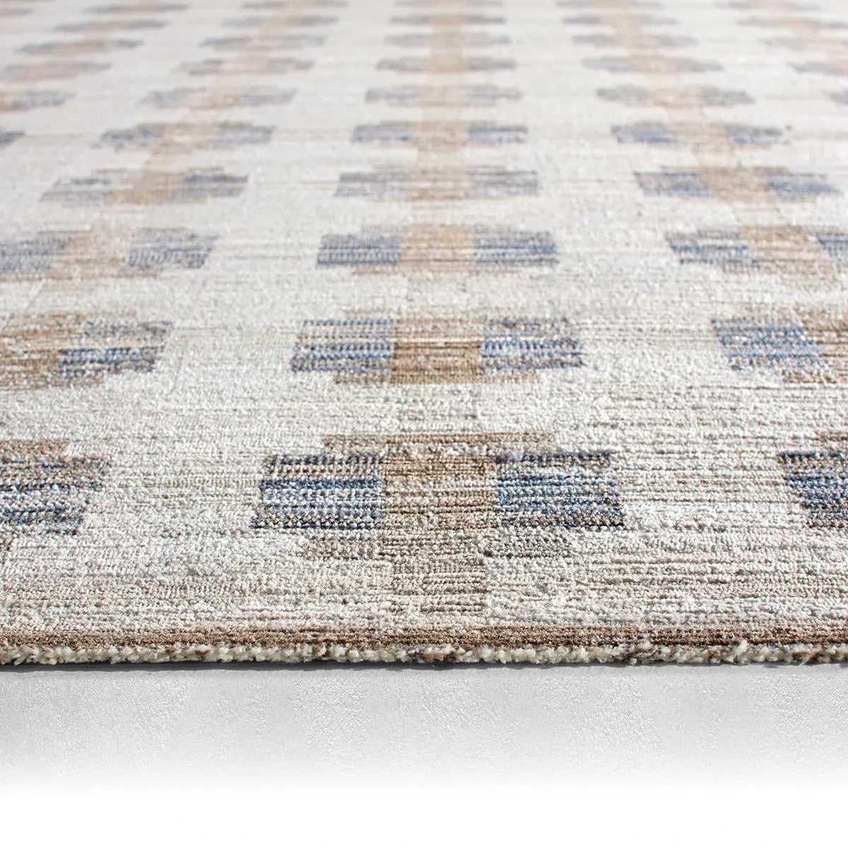 Close-up of a textured rug with geometric pattern on a light background