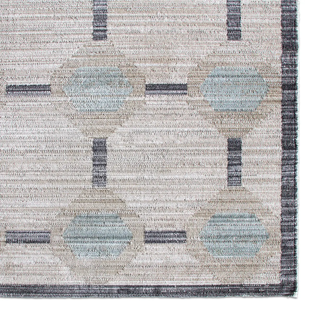 Close-up of a patterned rug with geometric design in neutral colors.