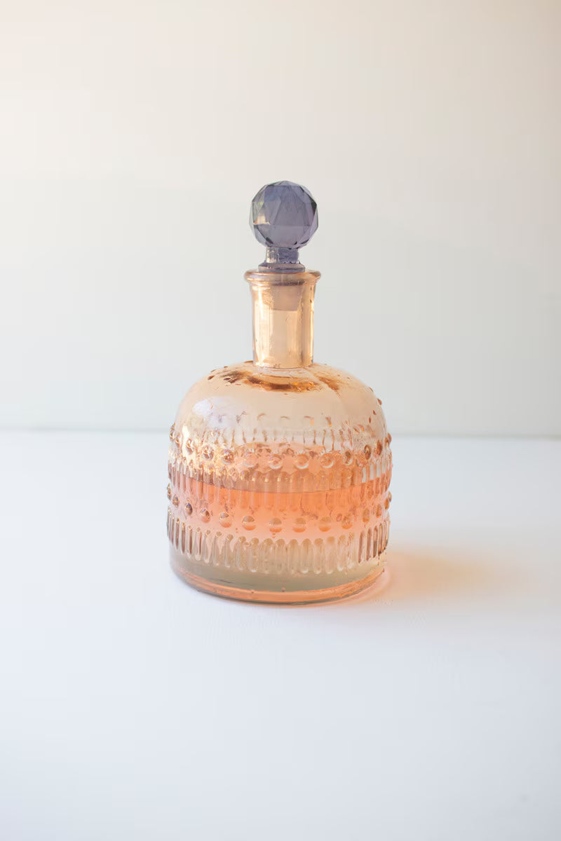 Decorative glass bottle with textured design on a white background