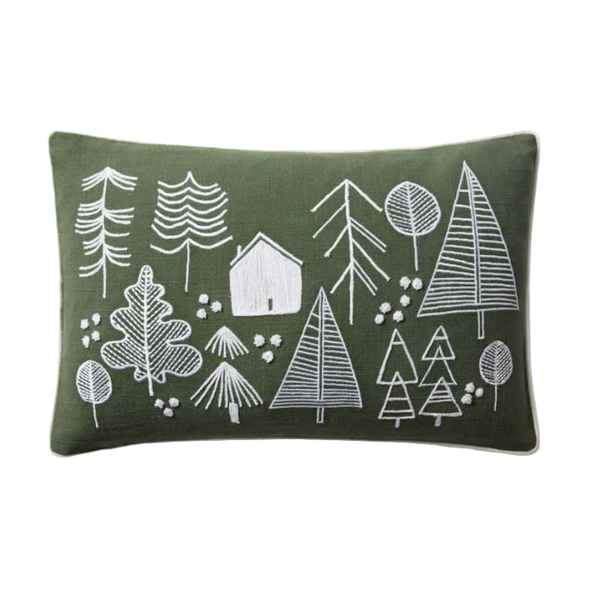 Green pillow with white forest design on a white background