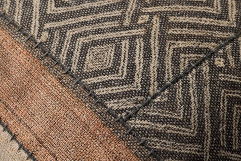 A square-shaped decorative pillow with a geometric pattern in beige, brown, and black colors, featuring a contrast flange and zipper closure.