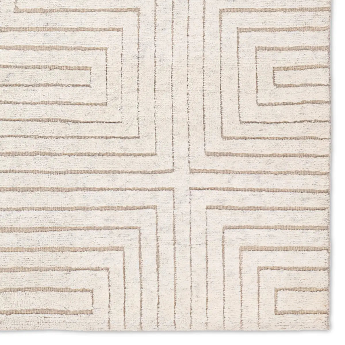 Close-up of a textured beige rug with geometric pattern