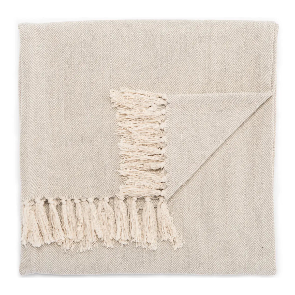 A folded beige woven throw blanket with a subtle herringbone pattern and fringed tassels, shown on a clean white background.