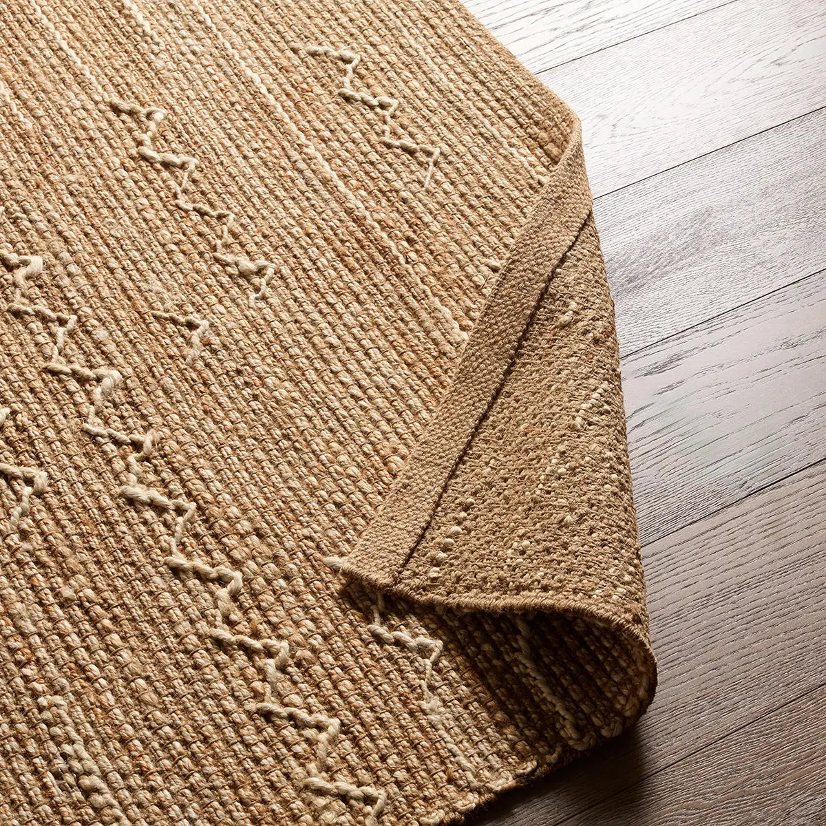 Textured beige rug on a wooden floor