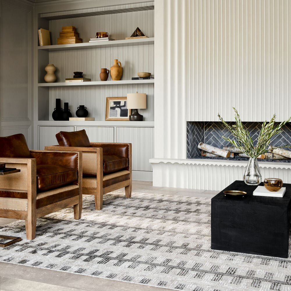 Living room with wooden chairs, a black coffee table, and decorative items on shelves.