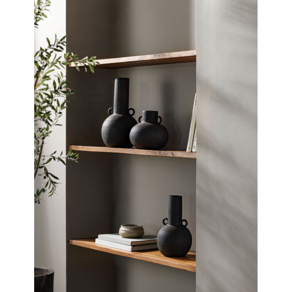 Wooden shelves with black vases and a plant against a neutral wall